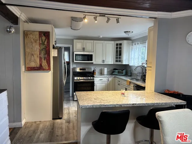 a kitchen with stainless steel appliances granite countertop a sink and a refrigerator