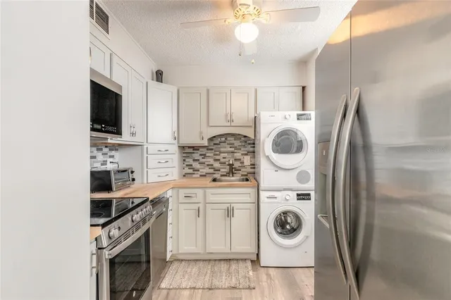 a kitchen with granite countertop a sink a stove and cabinets