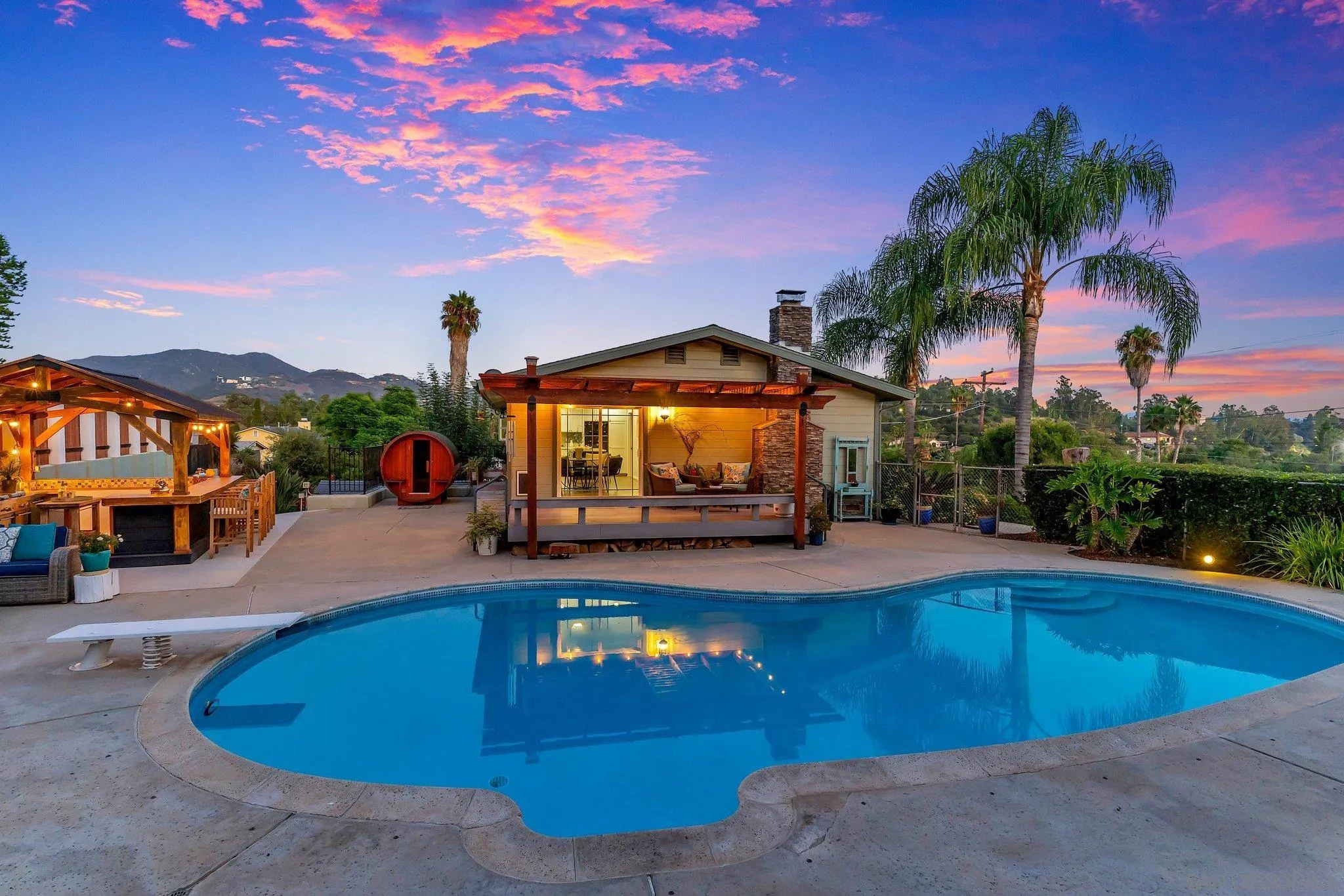1217 Memory Lane Vista, CA 92084 - Photo 43 of 72 a view of a swimming pool with lawn chairs and a dining table under an umbrella