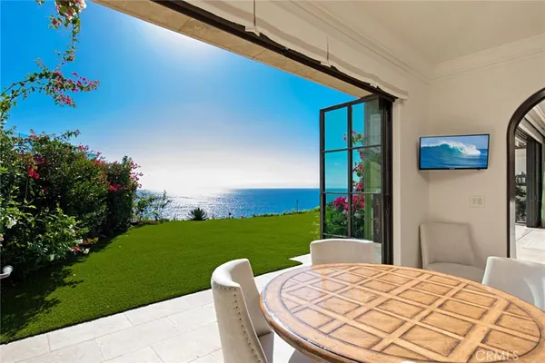 a view of a backyard with table and chairs potted plants with floor to ceiling window