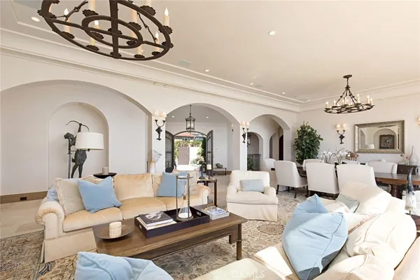 a living room with furniture a chandelier and a fireplace