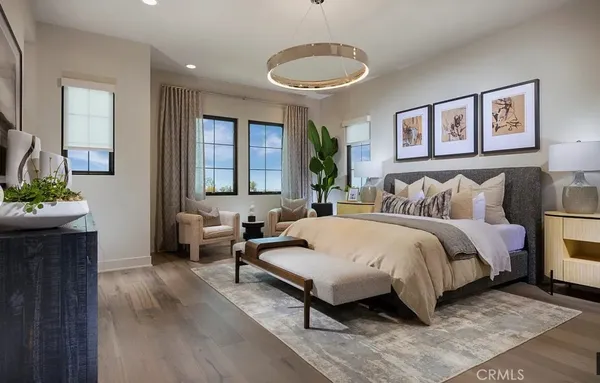 a spacious bedroom with a bed a couch and a potted plant