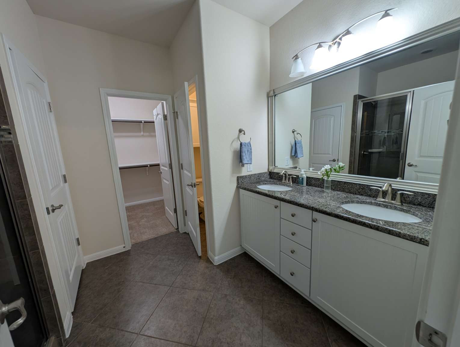 7301 Bandera Ranch Trail, Unit A Austin, TX 78750 - Photo 12 of 20 Double vanity with granite counters and expansive mirror anchors this functional primary bathroom.