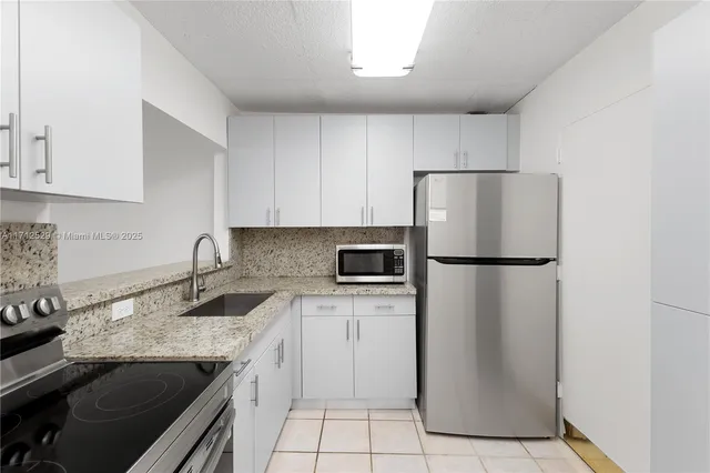 a kitchen with a sink a refrigerator and a stove