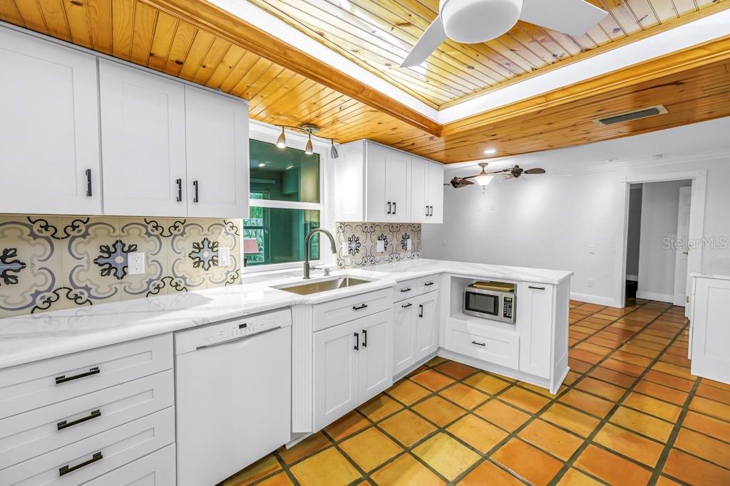 11174 90th Terrace Seminole, FL 33772 - Photo 18 of 35 a kitchen with granite countertop cabinets a sink a stove and a window