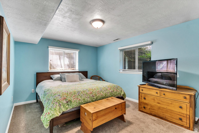 2863 Fallentine Road Sandy, UT 84093 - Photo 43 of 48 Carpeted room featuring two windows with white blinds, light blue walls, a textured white ceiling, and a flush mount light fixture