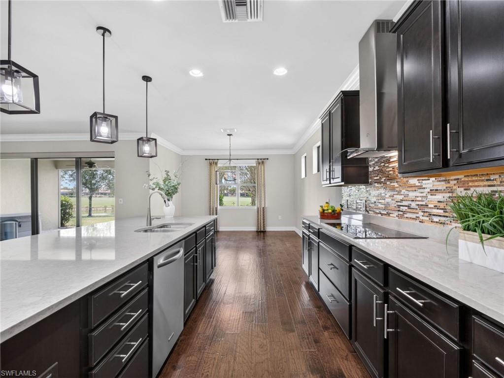 6124 Victory Drive Ave Maria, FL 34142 - Photo 19 of 50 a kitchen with stainless steel appliances granite countertop a sink a stove and a wooden floors