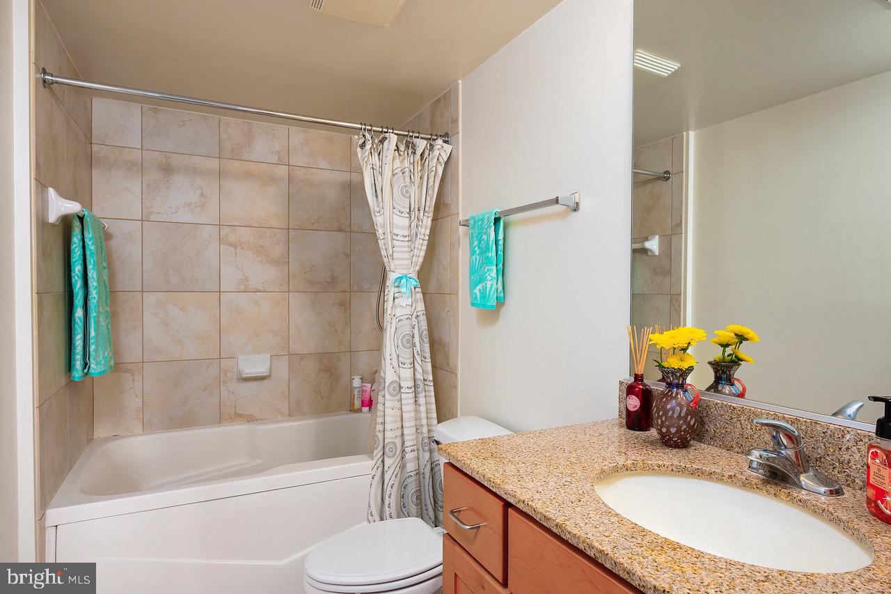 414 Water Street, Unit 1502 Baltimore, MD 21202 - Photo 12 of 32 a bathroom with a granite countertop sink and a mirror