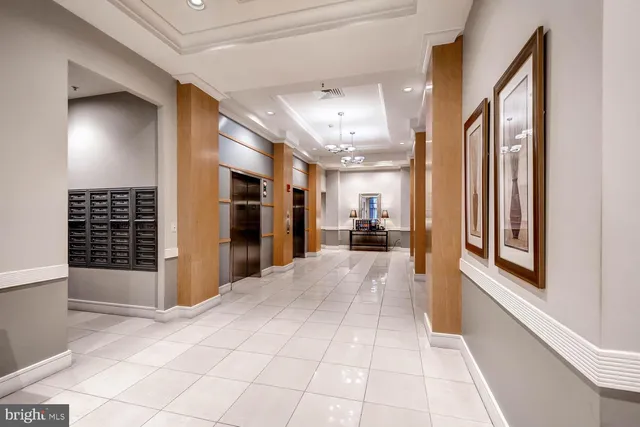 a view of a hallway with wooden floor and a living room