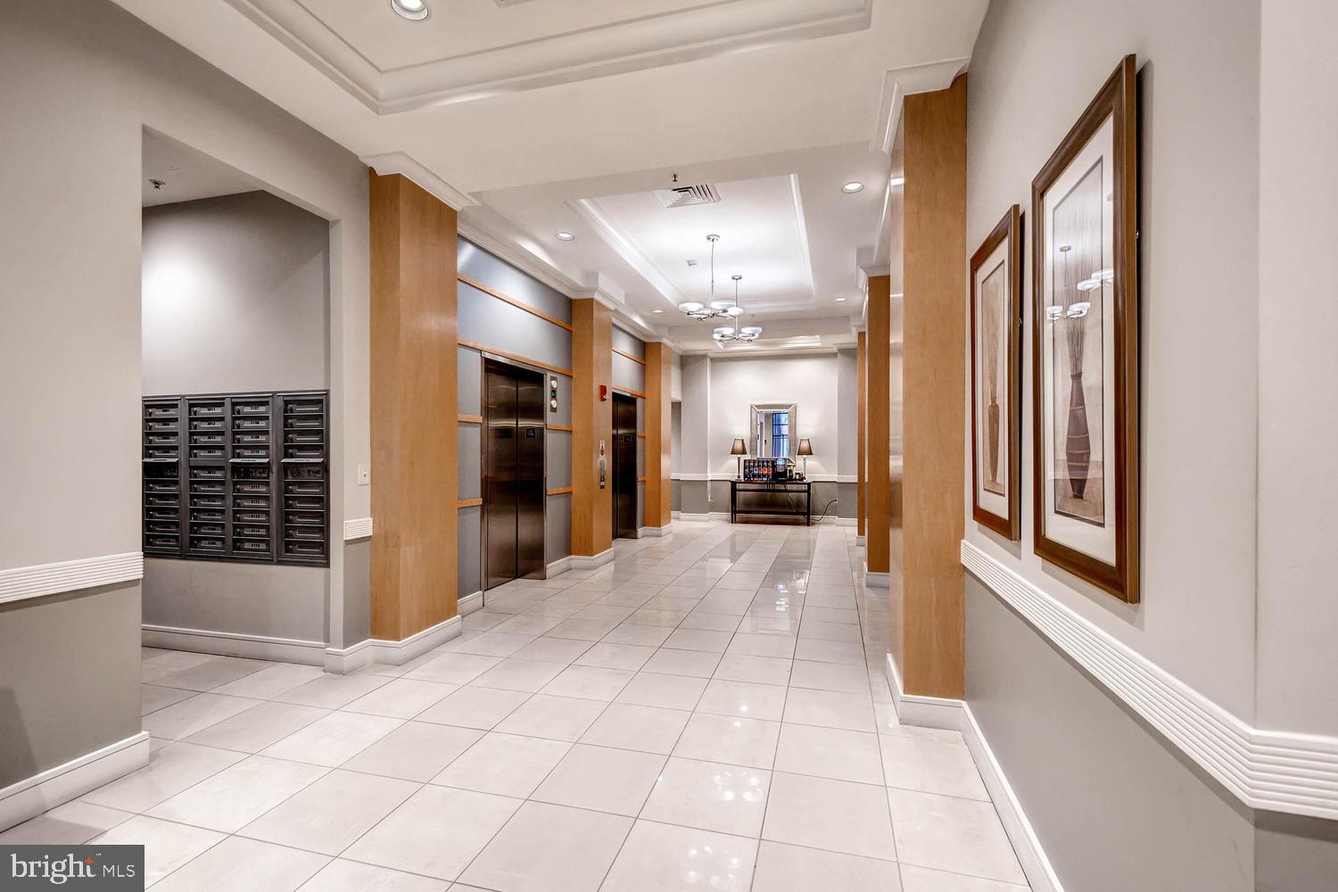 414 Water Street, Unit 1502 Baltimore, MD 21202 - Photo 24 of 32 a view of a hallway with wooden floor and a living room