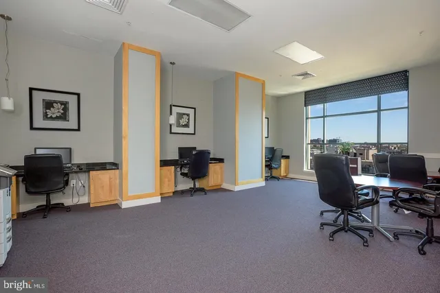 a view of a livingroom with workspace and a window
