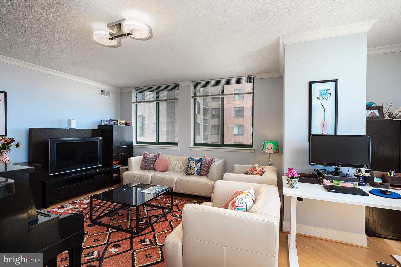 414 Water Street, Unit 1502 Baltimore, MD 21202 - Photo 3 of 32 a living room with furniture and a flat screen tv