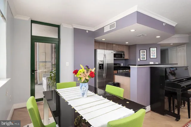 a room with stainless steel appliances kitchen island granite countertop furniture and a dining table