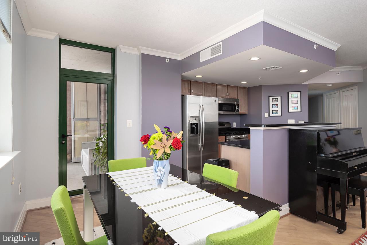 414 Water Street, Unit 1502 Baltimore, MD 21202 - Photo 6 of 32 a room with stainless steel appliances kitchen island granite countertop furniture and a dining table