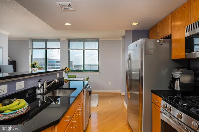 a kitchen with stainless steel appliances granite countertop a sink a stove and a refrigerator