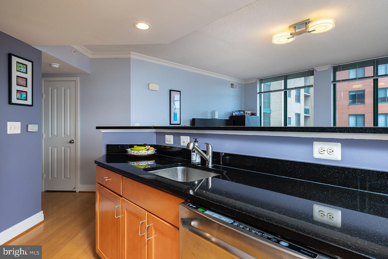 414 Water Street, Unit 1502 Baltimore, MD 21202 - Photo 8 of 32 a kitchen with granite countertop a sink and cabinets