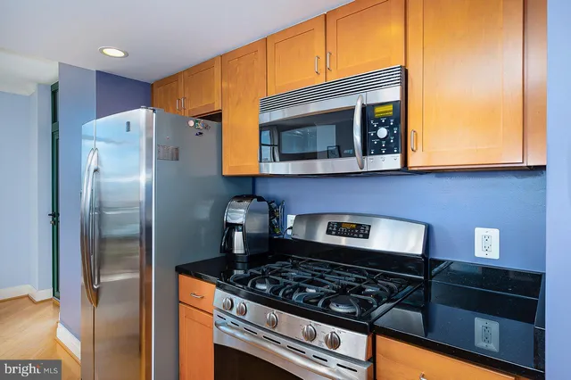 a kitchen with stainless steel appliances granite countertop a stove and a refrigerator