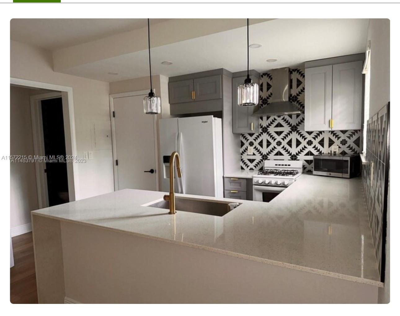 a kitchen with stainless steel appliances kitchen island a refrigerator and a sink