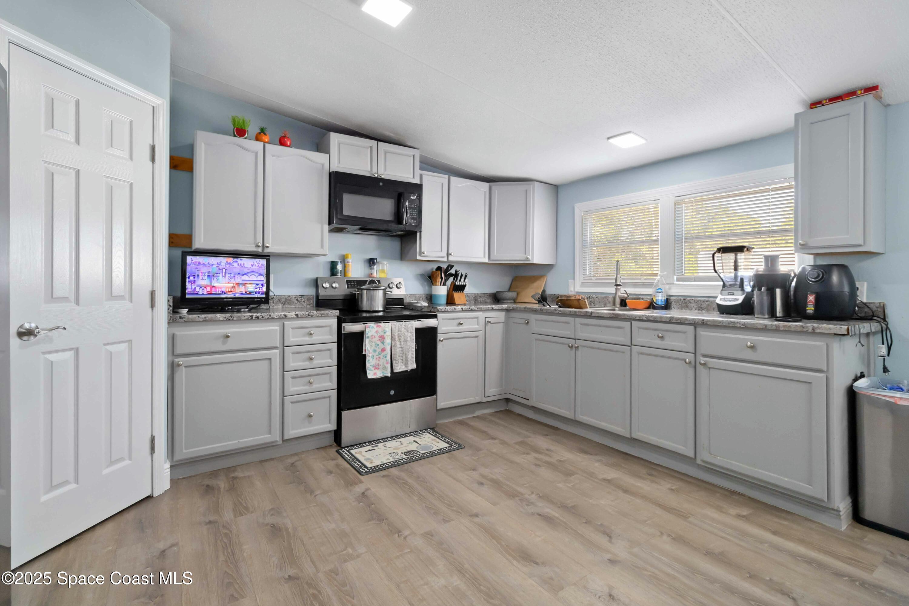 1686 Ackley Road Cocoa, FL 32922 - Photo 3 of 11 a kitchen with white cabinets and white appliances