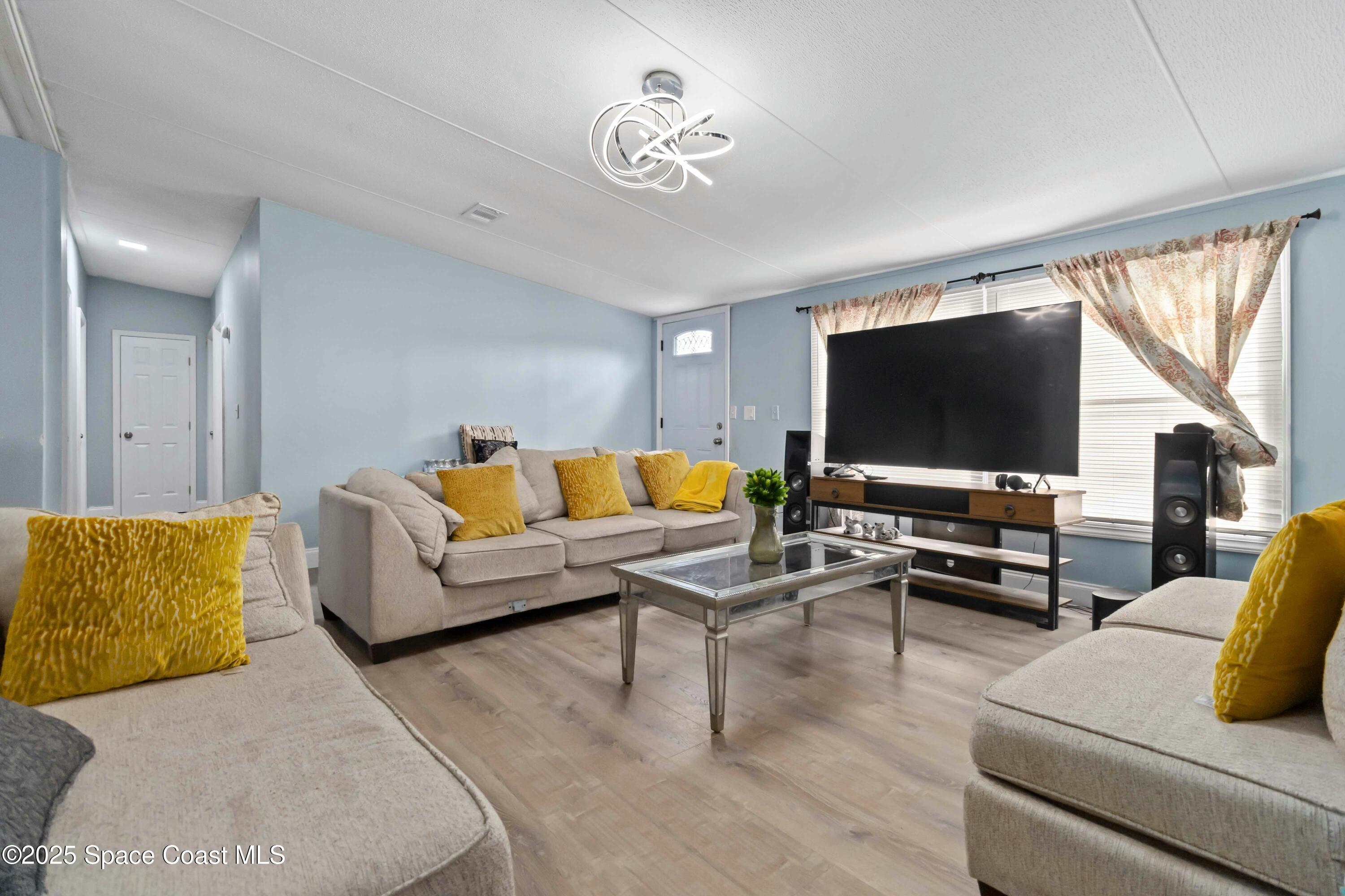 1686 Ackley Road Cocoa, FL 32922 - Photo 4 of 11 a living room with furniture and a flat screen tv