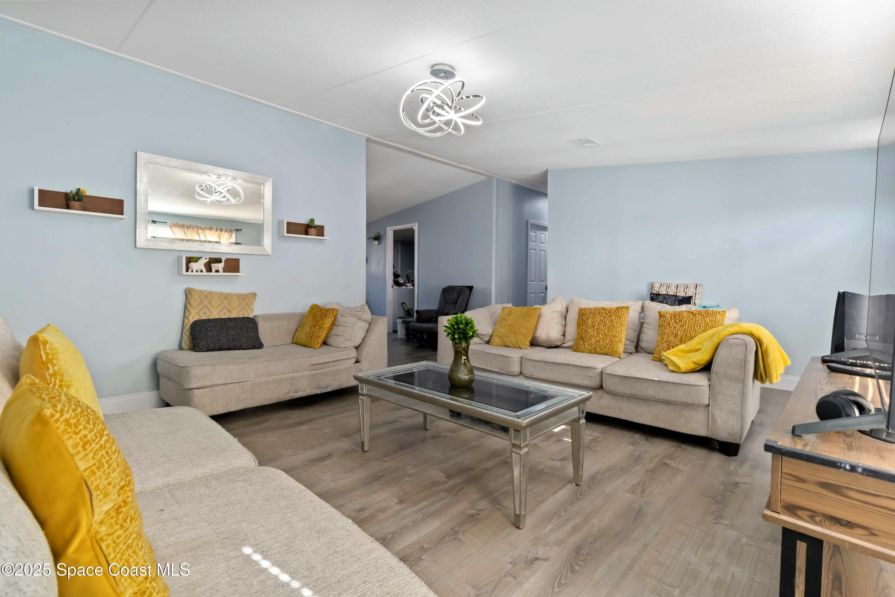 1686 Ackley Road Cocoa, FL 32922 - Photo 5 of 11 a living room with furniture and a chandelier