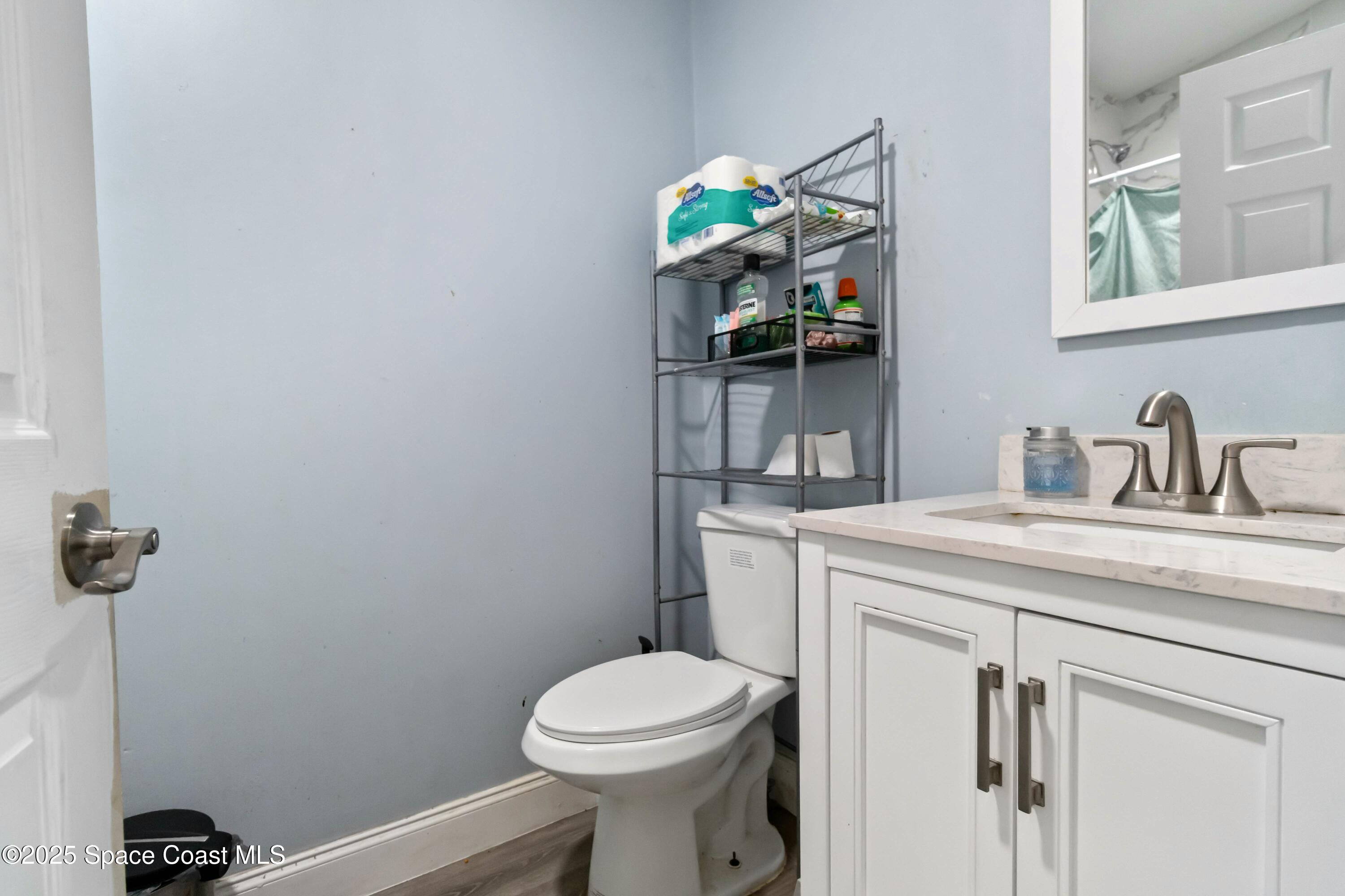 1686 Ackley Road Cocoa, FL 32922 - Photo 6 of 11 a bathroom with a toilet sink and mirror