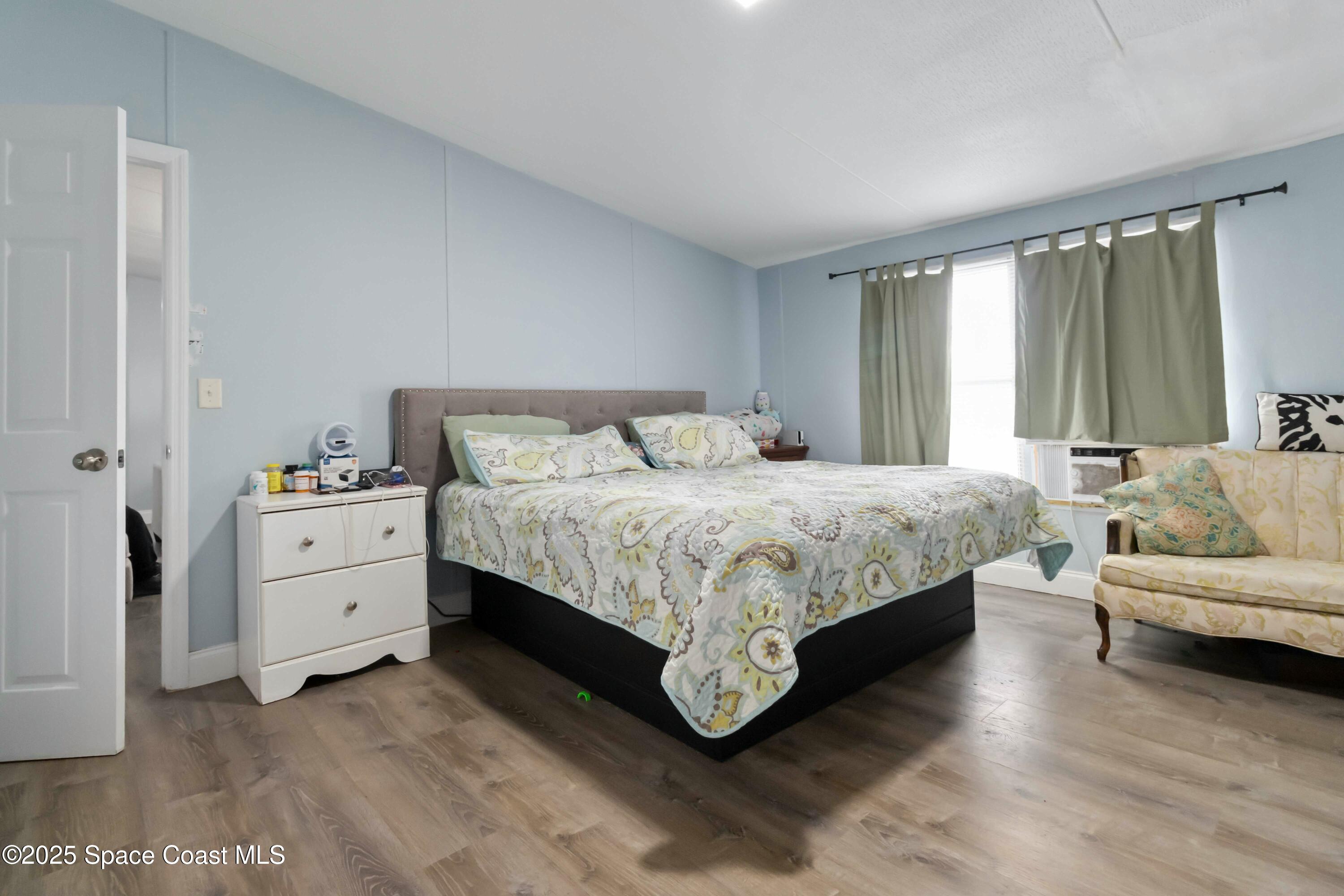 1686 Ackley Road Cocoa, FL 32922 - Photo 8 of 11 a bedroom with a white bed and white couch