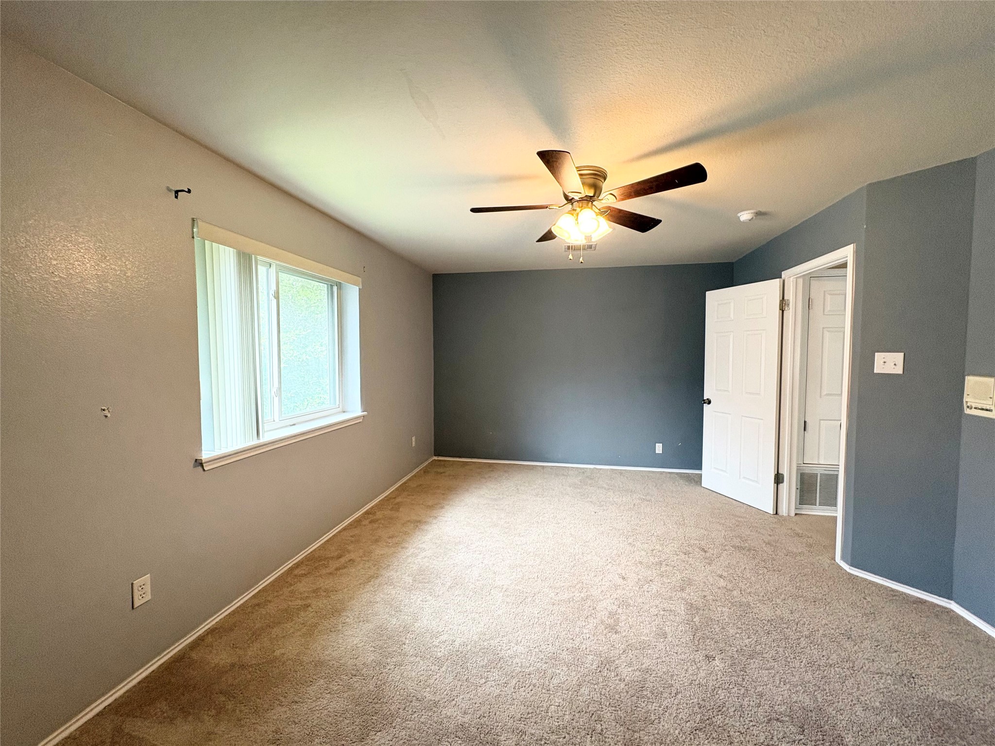 8103 Ephraim Road Austin, TX 78717 - Photo 22 of 35 A naturally illuminated bedroom offers comfort with soft carpeting and a functional ceiling fan.
