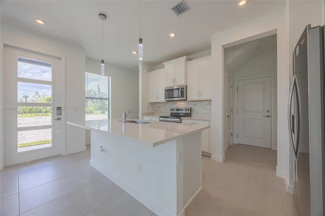 a view of a kitchen with refrigerator and a sink