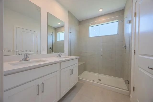 a bathroom with a shower sink vanity and mirror