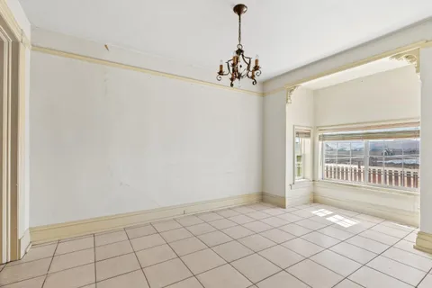 a view of a livingroom with a chandelier fan and windows