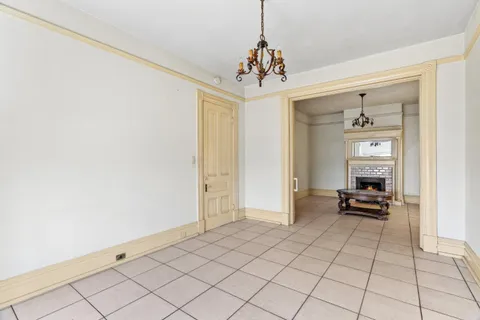 a view of a hallway with wooden floor and a chandelier