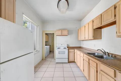 a kitchen with stainless steel appliances granite countertop a sink and a refrigerator