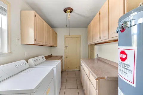 a utility room with stainless steel appliances granite countertop a sink and dishwasher
