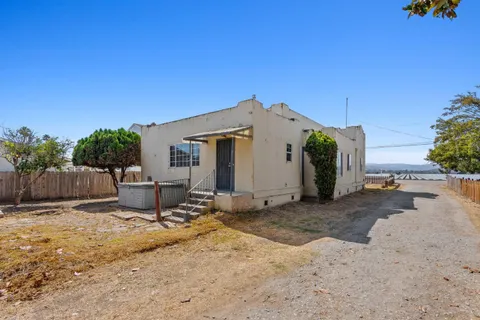 a view of a patio with a table and chairs under an umbrella
