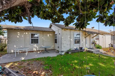 a backyard of a house with table and chairs