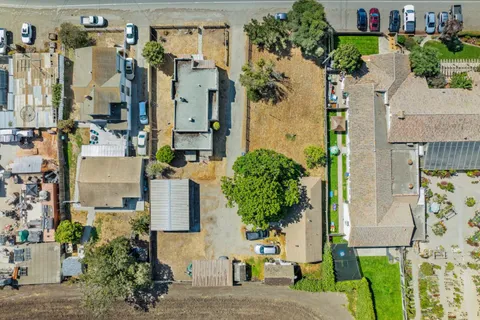an aerial view of residential houses with outdoor space and parking