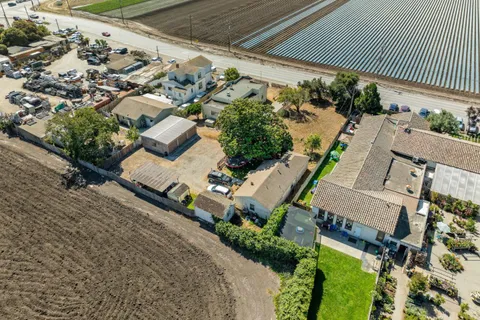 an aerial view of a house with a yard and wooden fence