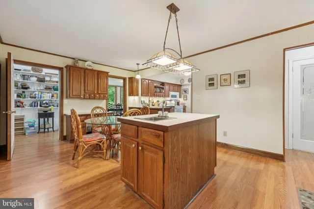 a view of a dining room and livingroom with furniture wooden floor a chandelier