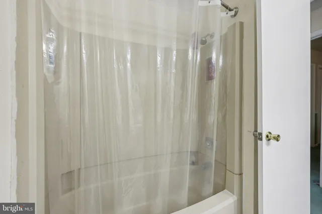 a room with stainless steel appliances furniture a chandelier and a bookshelf