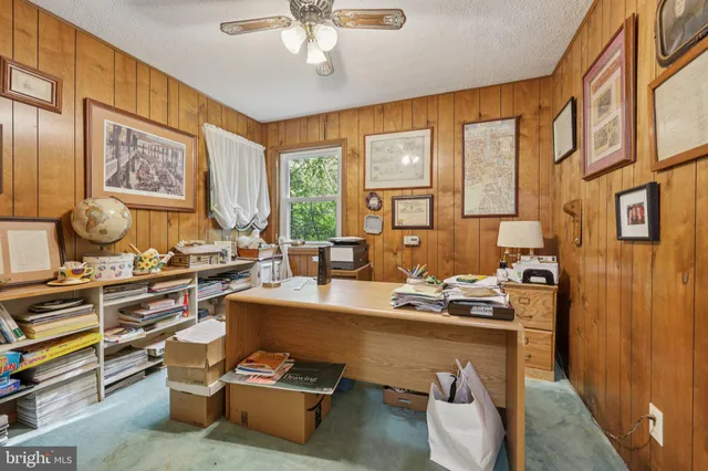 a balcony with wooden floor outdoor seating and yard in the back
