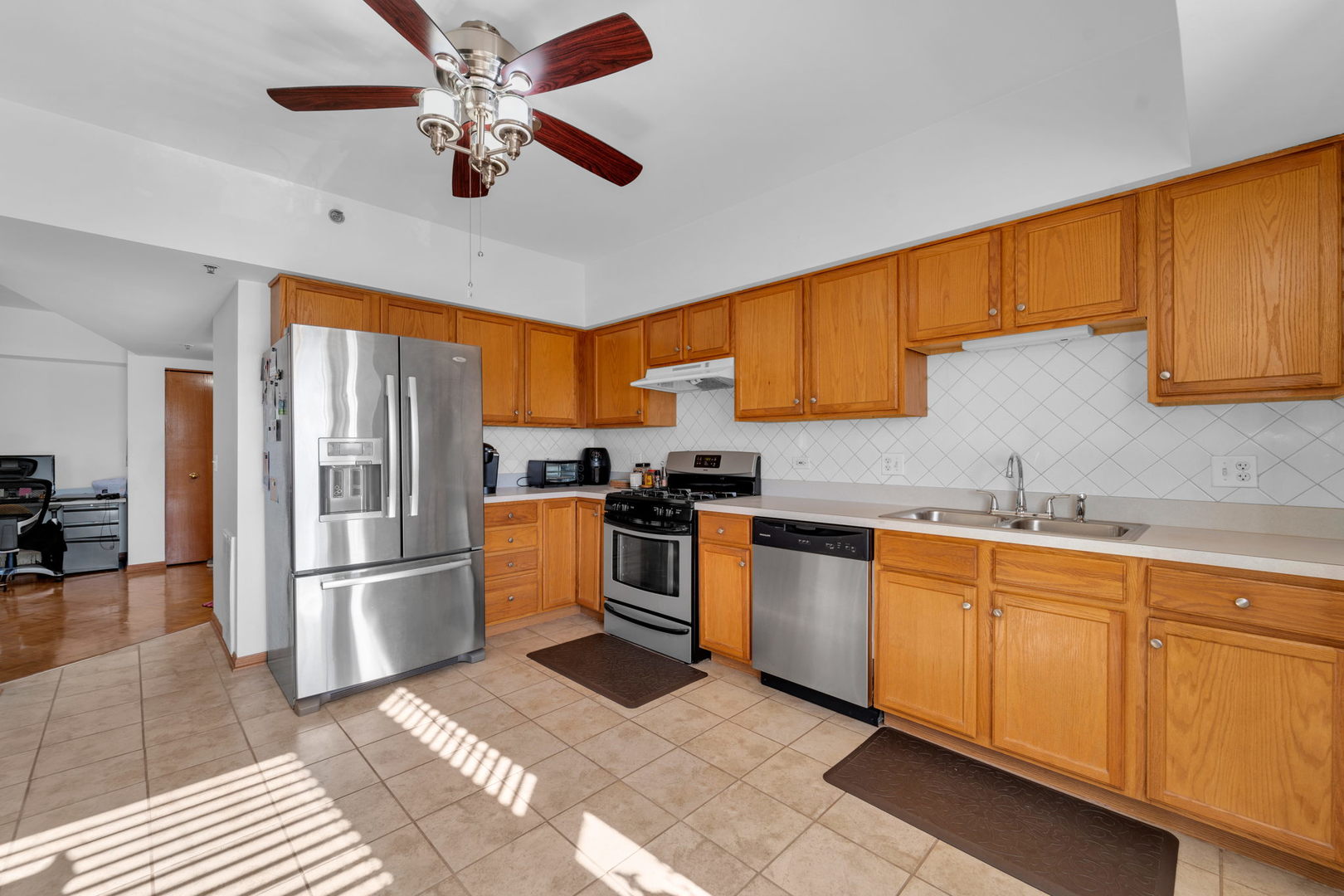 717 North 5th Avenue, Unit 302 Addison, IL 60101 - Photo 5 of 25 a kitchen with stainless steel appliances granite countertop a refrigerator a sink dishwasher a stove and white cabinets with wooden floor