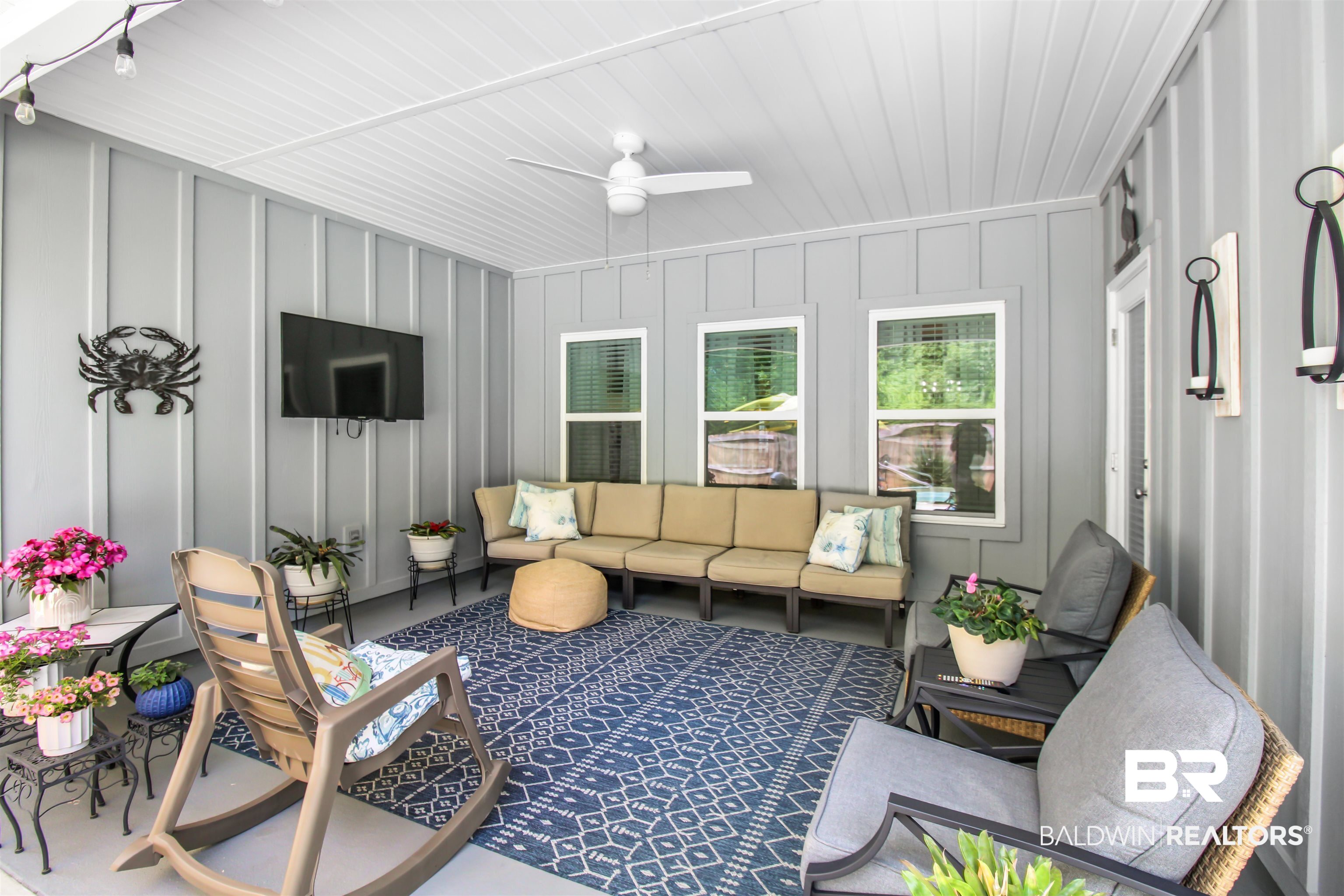 1885 Carly Street Foley, AL 36535 - Photo 5 of 40 Screened porch featuring light gray board-and-batten walls, a white beadboard ceiling, a ceiling fan, and string lighting