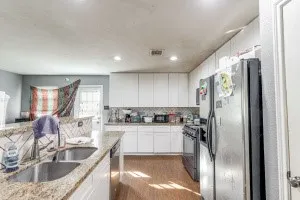 a kitchen with kitchen island granite countertop a sink stainless steel appliances cabinets and a counter top space