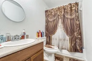 a bathroom with a granite countertop sink a toilet and a mirror