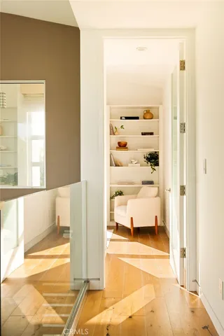 a bedroom with a bed and a chair with the wooden floor