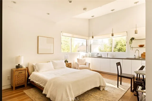 a living room with furniture a large window and wooden floor