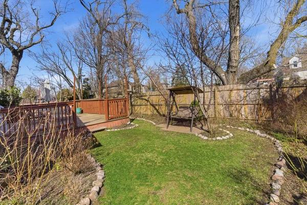a view of backyard with wooden fence and large trees