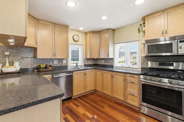 a kitchen with stainless steel appliances granite countertop a stove a sink and a microwave