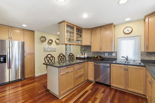 a kitchen with stainless steel appliances granite countertop a stove a sink and a refrigerator